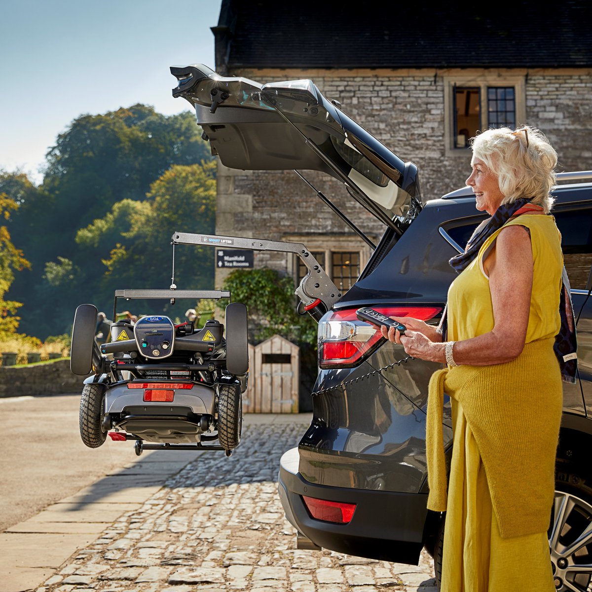 Autochair Smart Lifter hoisting a mobility scooter into a vehicle cargo area