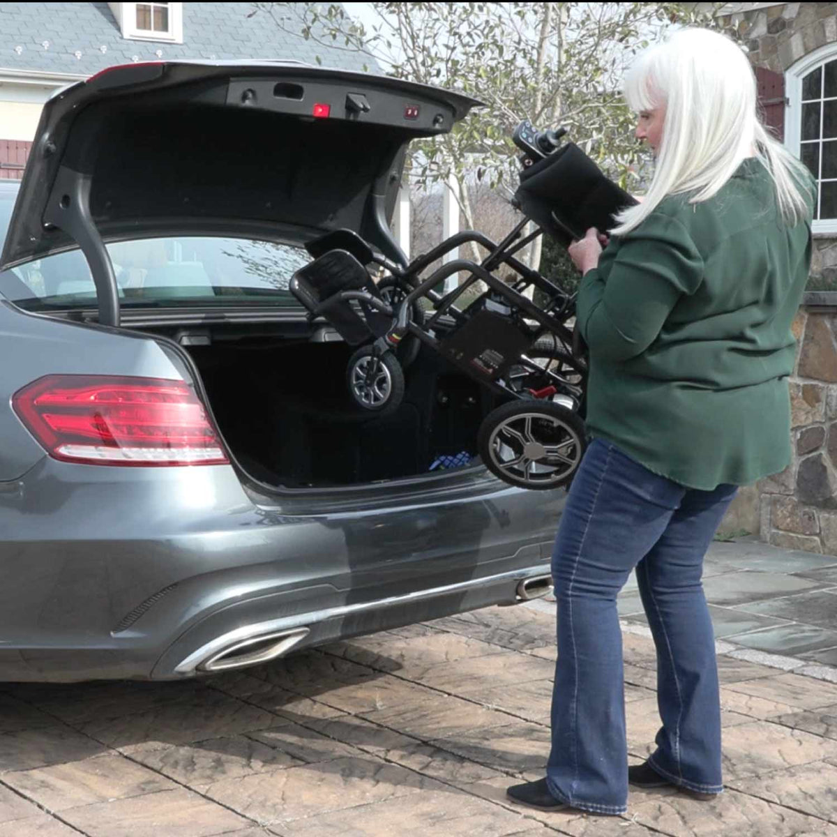 Traveler loading a folded Journey Air Elite power chair into a vehicle