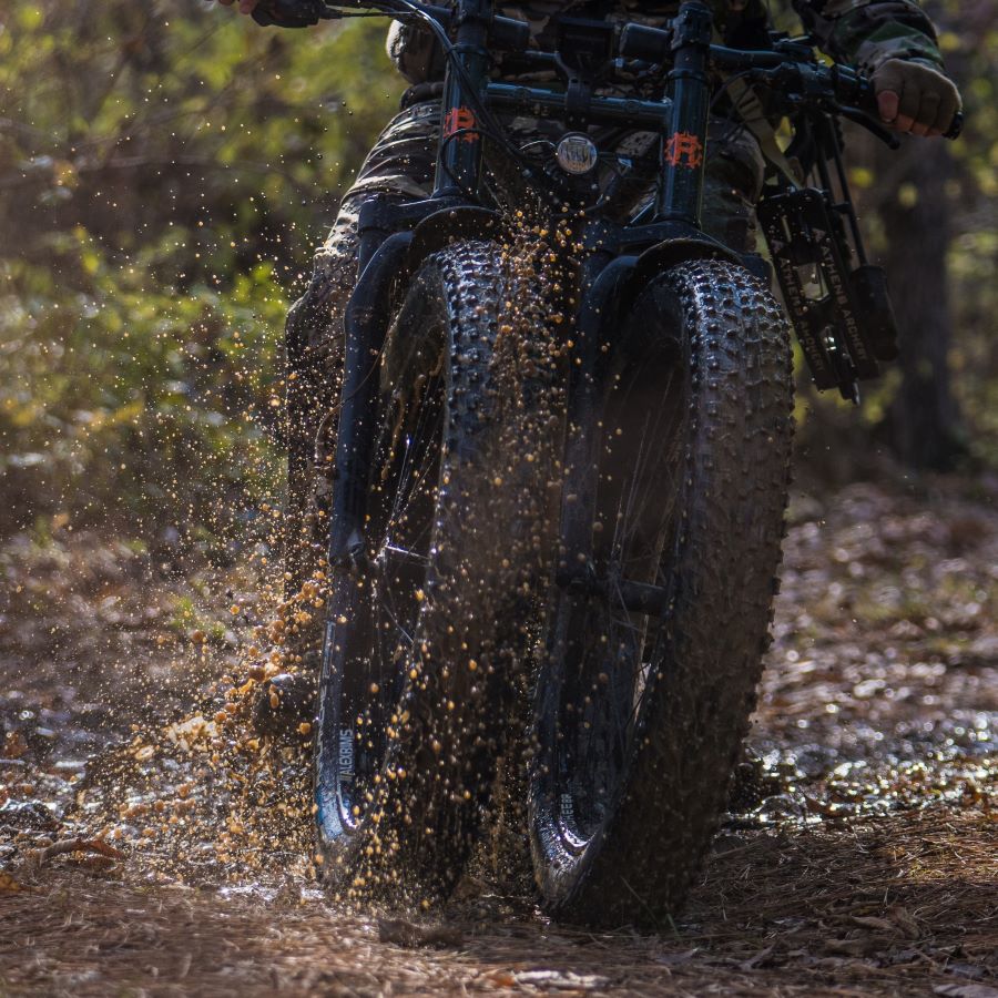 Rungu Dualie dual-front-wheel electric bike riding through wet off-road terrain